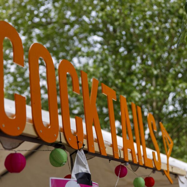 Orangenes Schild mit dem Schriftzug „Cocktails“.