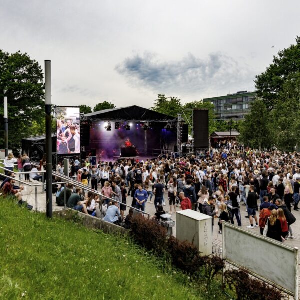 Festivalbesucher stehen vor einer Open-Air-Bühne.